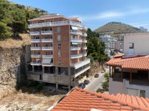 un edificio alto de ladrillo con balcones y una calle en Blue Breeze Attic Apartments, en Sarandë