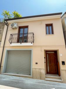 ein Haus mit einer Garagentür und einem Balkon in der Unterkunft Aurelia Casa Vacanze in Mirabella Eclano