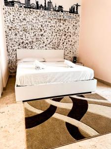 a white bed in a room with a wall at Sina Rent Room in Rome