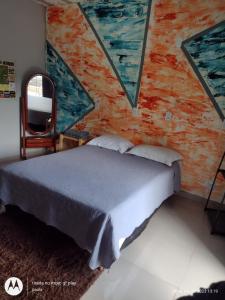 Caparaó Velho的住宿－Recanto Serra Monte，卧室配有一张床,墙上挂有绘画作品