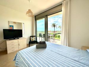 1 dormitorio con 1 cama, TV y ventana en Apartamento ideal para desconectar en L'Ampolla