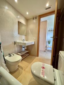 a bathroom with a white toilet and a sink at Apartamento ideal para desconectar in L'Ampolla