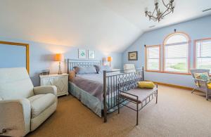 a bedroom with a bed and a couch and a chair at By the Sea in Kill Devil Hills +183 photos