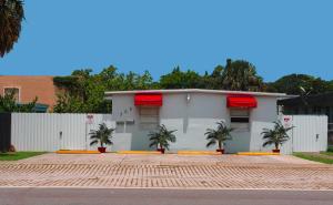 a white house with palm trees in front of it at Luxury House with delightful beach Style! in Dania Beach