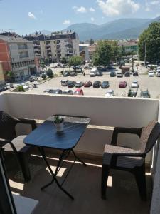 a table and chairs on a balcony with a parking lot at STE-FI APARTMANS in Gostivar
