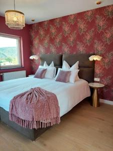 a bedroom with a large bed with red walls at Cha Cha de Loup in Rendeux