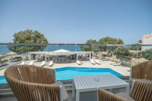 een patio met een zwembad, stoelen en een tafel bij Alexia Beach Hotel in Agia Marina Nea Kydonias