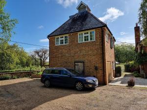 um carro estacionado em frente a uma casa de tijolos em Square Oast Studio em West Malling