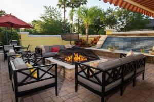 a patio with a fire pit with chairs and a couch at Hampton Inn & Suites Jacksonville Deerwood Park in Jacksonville