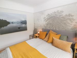 a bedroom with a bed with yellow pillows at Beech Croft in Keswick
