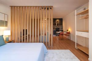 1 dormitorio con 1 cama blanca y comedor en DOISPONTOZERO Bragas, en Oporto