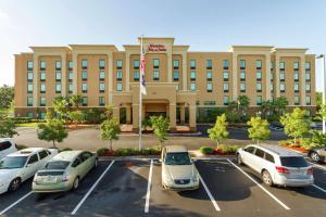 un gran edificio con coches estacionados en un estacionamiento en Hampton Inn & Suites Jacksonville-Airport en Jacksonville