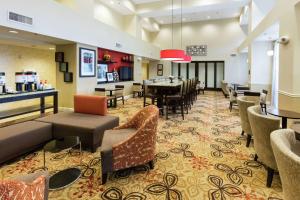 hol hotelu z krzesłami i barem w obiekcie Hampton Inn & Suites Jacksonville-Airport w mieście Jacksonville