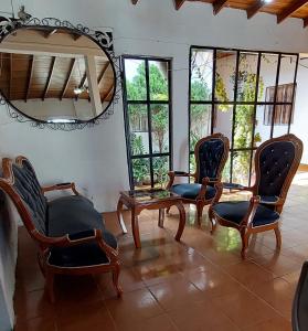 a room with chairs and a mirror and windows at HOTEL CASA COLONIAL in San Antonio del Táchira