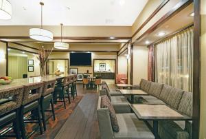 um átrio do hotel com mesas e cadeiras e um bar em Hampton Inn Beloit em Beloit