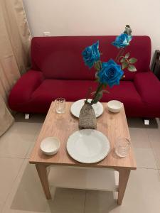 a coffee table with plates and a vase with blue roses at Corniche, Abu Dhabi in Abu Dhabi