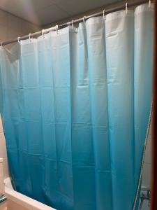 a blue shower curtain in a bathroom at Corniche, Abu Dhabi in Abu Dhabi