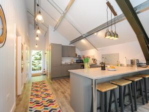 a kitchen with a large counter and stools at The Shed in Liskeard