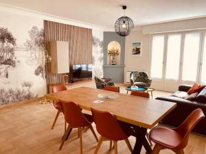a living room with a wooden table and chairs at Appartement spacieux centre ville et plage à pied in Concarneau