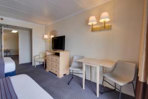 a hotel room with a bed and a desk with a television at Flamingo Motel in Ocean City