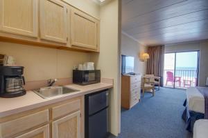 a kitchen with a sink and a room with a bed at Flamingo Motel in Ocean City