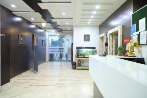 a lobby with a white counter and a fish tank at Western Keys Hotel in Bangalore