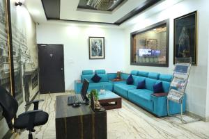 a living room with a blue couch and a table at Western Keys Hotel in Bangalore