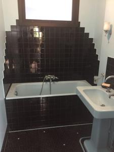 a bathroom with a bath tub and a sink at La petite maison et ses quatre vélos in Rezé