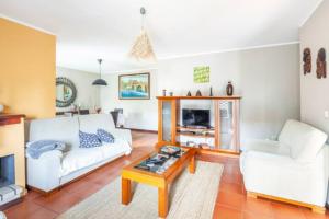 uma sala de estar com um sofá branco e uma mesa de centro em Villa Clementina em Barcelos