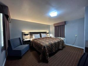 a hotel room with a bed and a chair at Rodeway Inn & Suites in Walhalla