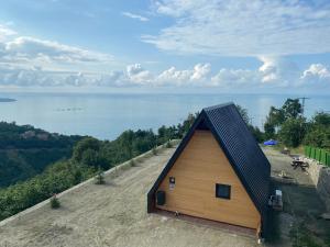 a cabin with a black roof on a hill next to the water at Private Bungalow in Trabzon