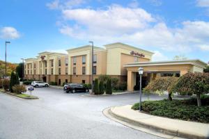 ein großes Gebäude mit Autos auf einem Parkplatz in der Unterkunft Hampton Inn Lewisburg in Lewisburg