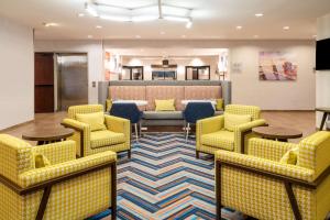 a waiting room with yellow chairs and tables at Hampton Inn Irvine/East Lake Forest in Foothill Ranch