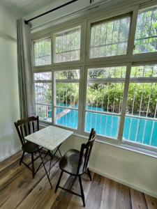 een tafel en stoelen in een kamer met ramen bij Carmel Emerald in Haifa
