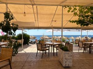 a restaurant with tables and chairs and the ocean at Panorama Chantall-izby,apartmány s výhľadom na more in Ravda