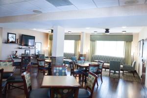 a dining room with tables and chairs and windows at Hampton Inn - North Platte in North Platte