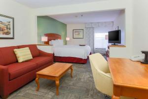 a hotel room with a couch and a bed at Hampton Inn Lexington South in Lexington