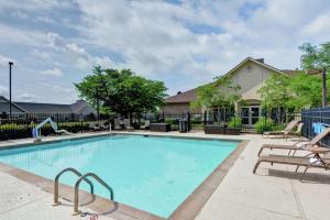 a swimming pool with chairs and a fence at Homewood Suites by Hilton Lexington Fayette Mall in Lexington