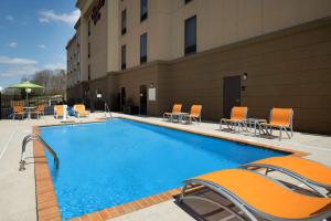 a large swimming pool with chairs and a building at Hampton Inn Lenoir City in Lenoir City