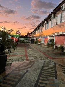 uma rua vazia em frente a um edifício ao pôr do sol em Motel Desejo em Porto Alegre