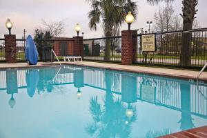 una piscina con acqua blu di fronte a una recinzione di Hampton Inn & Suites Jennings a Jennings