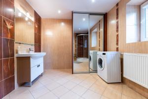 a bathroom with a washing machine and a sink at Willa Malinówka - ogród wypoczynkowy z widokiem na Śnieżkę in Karpacz