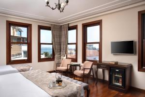 Habitación de hotel con cama y TV en Bender Hotel en Estambul