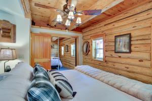 duże łóżko w pokoju z drewnianymi ścianami w obiekcie Lake Almanor Cabin with Deck and Beach Access w mieście Westwood