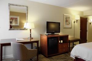 a hotel room with a bed and a flat screen tv at Hampton Inn Lima in Lima