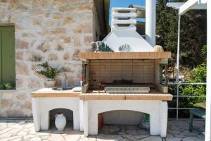 a outdoor kitchen with a stove and a sink at Agnis House in Antípaxos