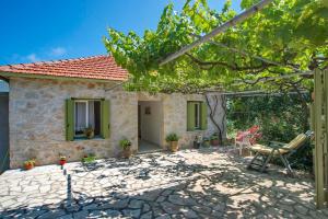 a cottage with a garden and a patio at Agnis House in Antípaxos