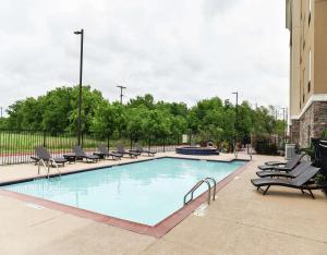a large swimming pool with lounge chairs next to a building at Hampton Inn & Suites Bay City in Bay City