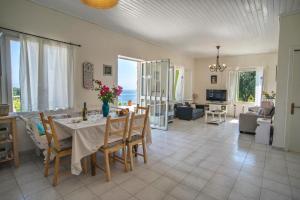 a living room with a table and chairs and a couch at Agnis House in Antípaxos