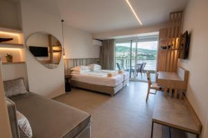 a hotel room with a bed and a balcony at Paralimnio Suites in Kastoria